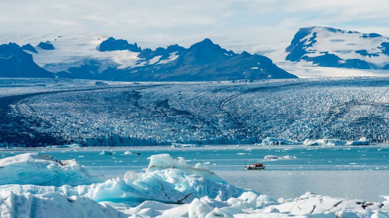 A hiker traversing a blue glacier in Iceland.